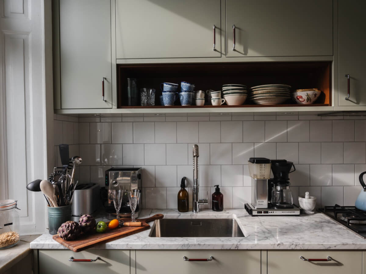 Gray Tones and Built-in Storage in a Charming Corner Apartment 11 kitchen marble countertop open and closed cabinets white tiles