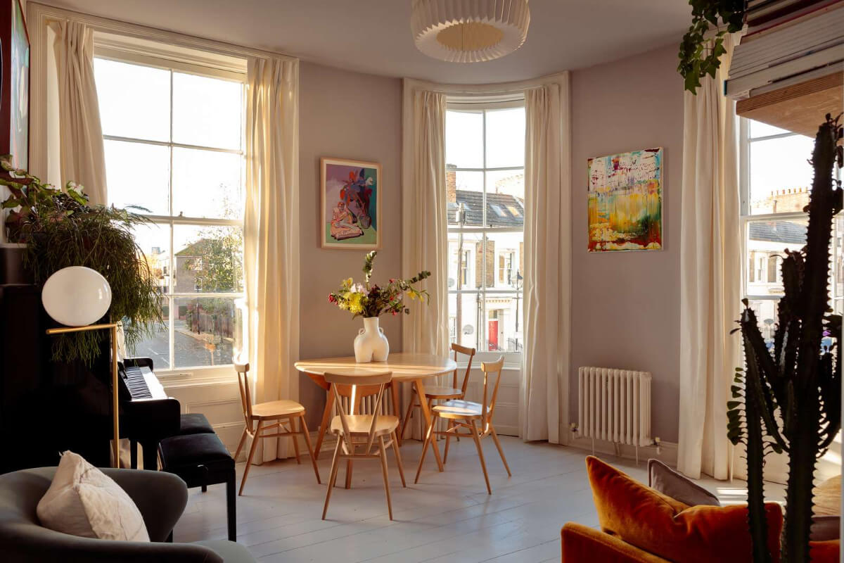 A Corner Apartment with Large Windows in a Former London Pub 1 living room gray floorboards rounded wall with window