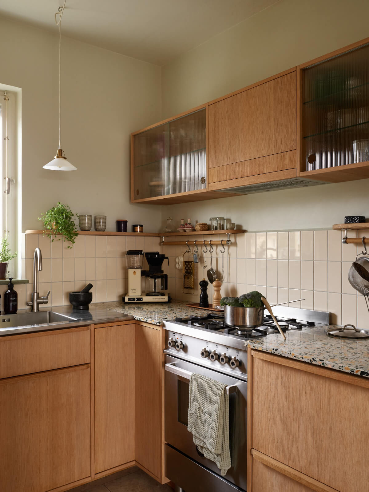 oak kitchen with terrazzo countertop and beige backsplash tiles