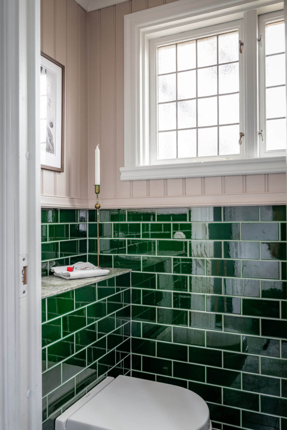 Turn-of-the-Century Charm Meets Modern Comfort in a Swedish House 15 powder room green tiles pink wood paneling