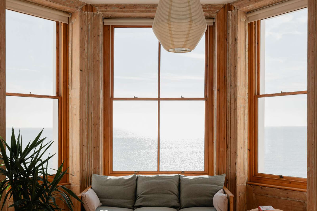 Bespoke Furniture in a Restored Seaside Apartment in England 2 raw wooden window frames