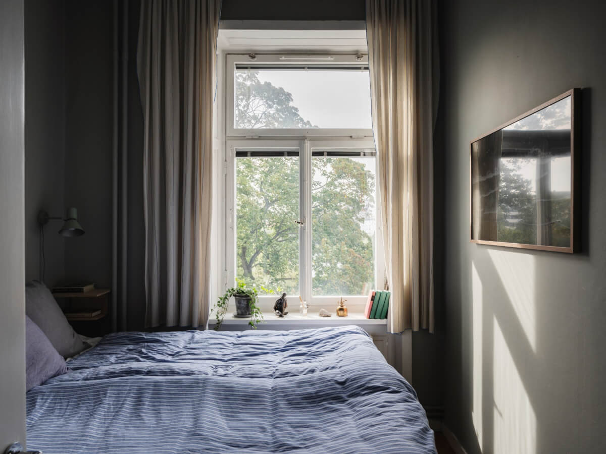 Gray Tones and Built-in Storage in a Charming Corner Apartment 14 small moody bedroom striped blue bedding