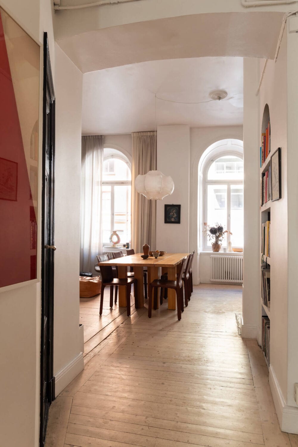 Arches and a Wall Mural in a Swedish Apartment 13 view into living space wooden floor storage niche