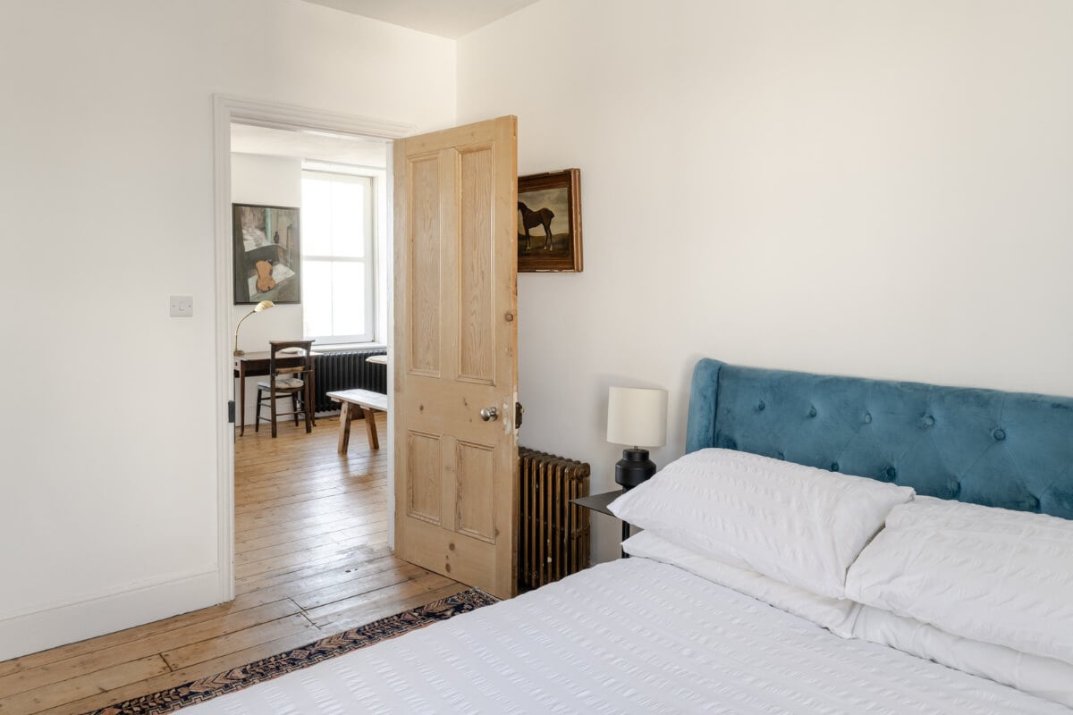 A Small Victorian Apartment by the Sea in Cornwall 12 white bedroom blue velvet bedframe