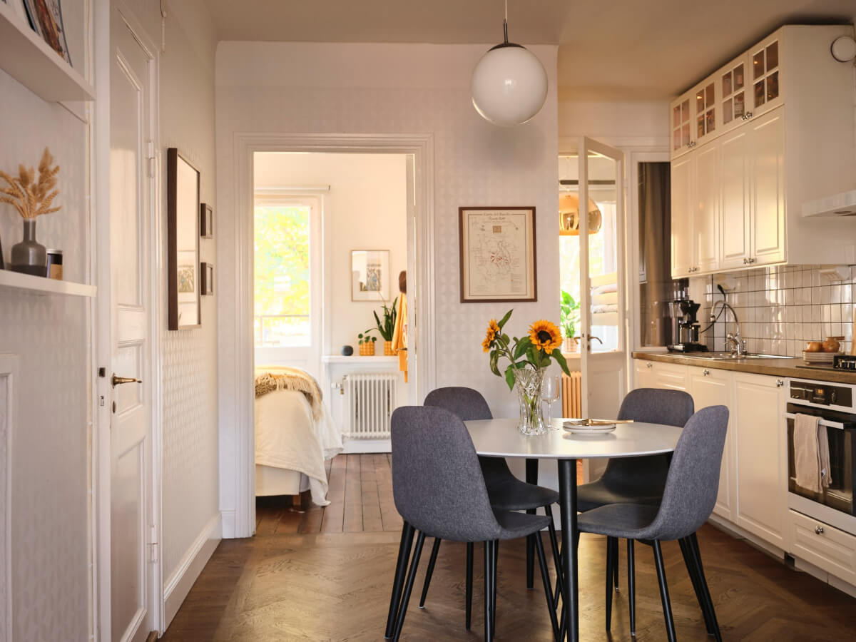 A Light-Filled 1920s Apartment with Two Spacious Balconies 18 white kitchen with round dining table