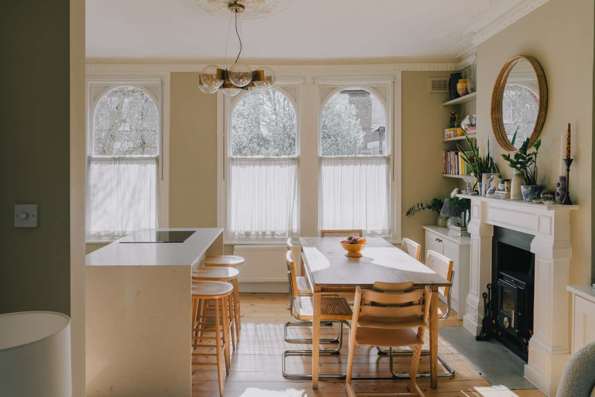 A Serene Color Palette and Built-In Shelves in a London Duplex 7 arched windows kitchen with dining table fireplace
