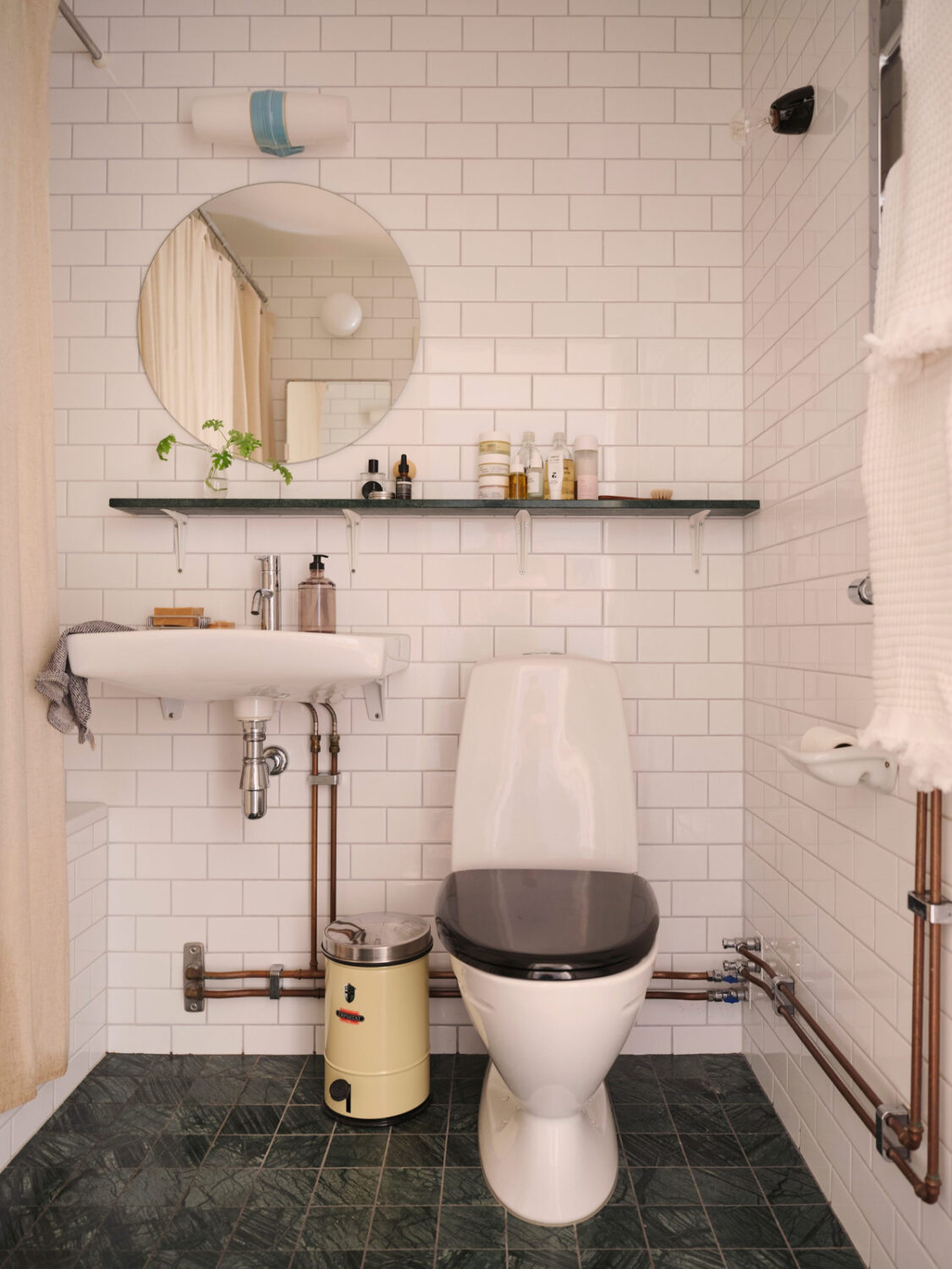 A Light-Filled Functionalist Apartment in Stockholm 16 bathroom white tiles round mirror shelf