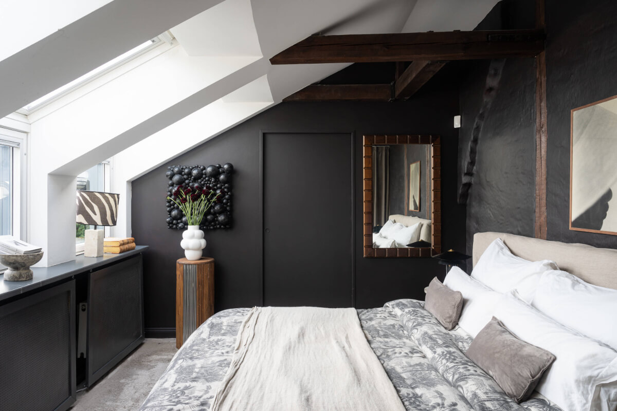 black bedroom slanted ceiling skylights wooden beams