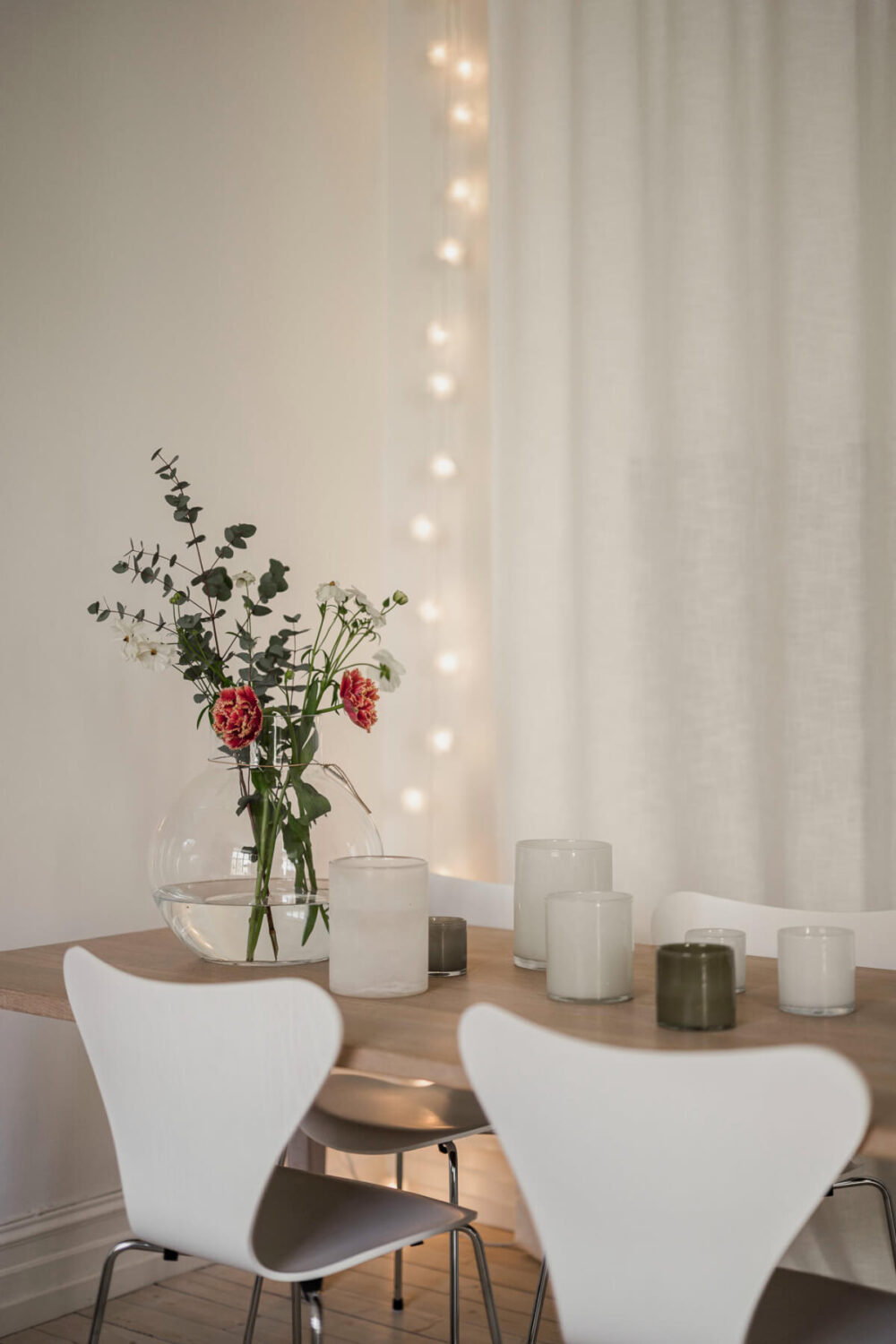 A Bright Swedish Apartment with Period Features and a Green Kitchen 14 dining table string lights