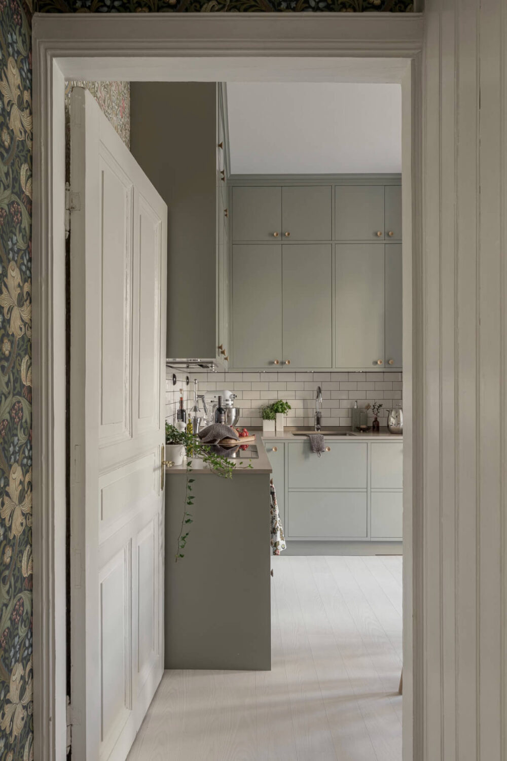 A Bright Swedish Apartment with Period Features and a Green Kitchen 4 double upper cabinets green kitchen