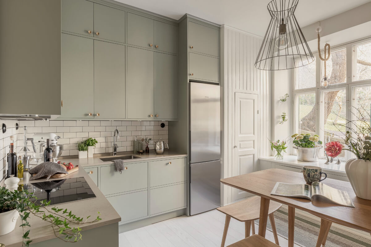 kitchen green cabinets white floorboards dining table
