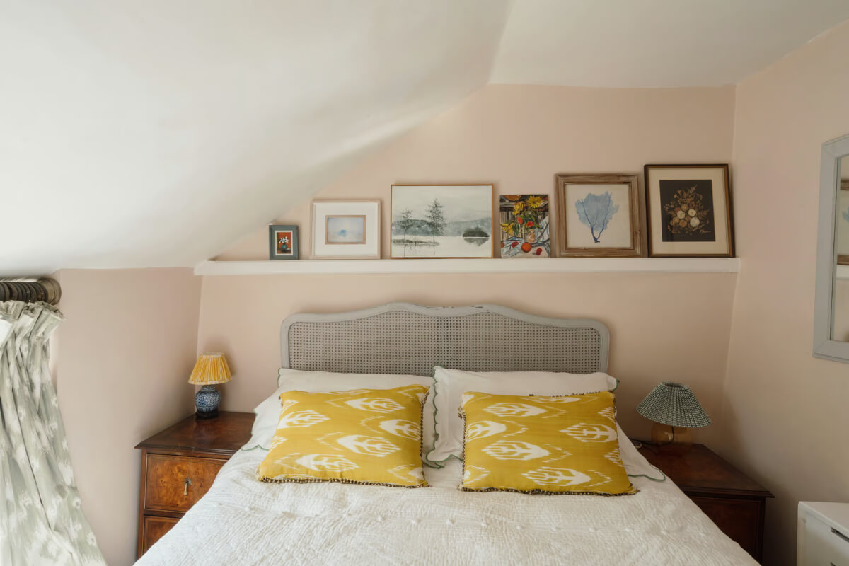 light pink cottage bedroom display shelf above bed