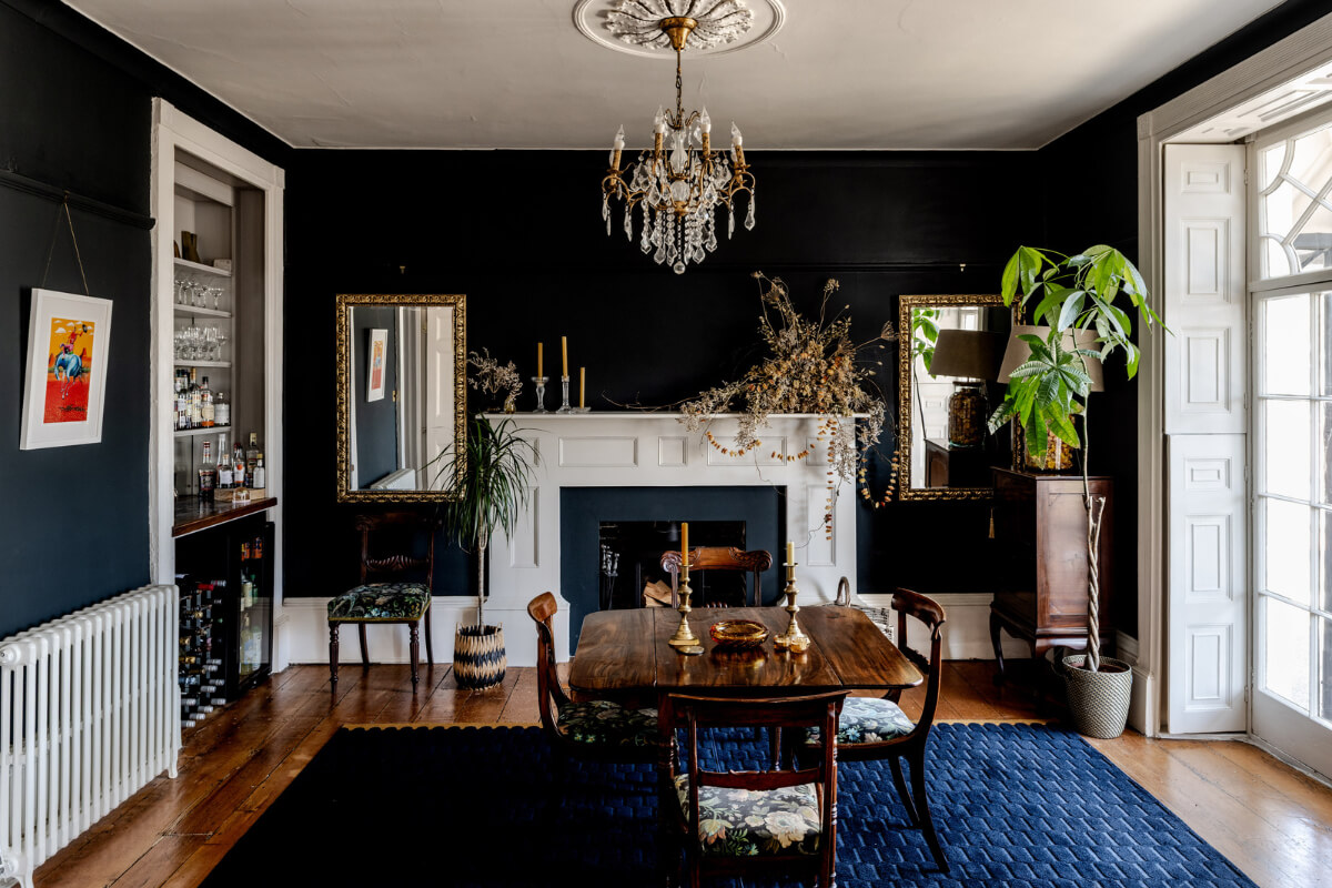moody dining room large blue rug fireplace