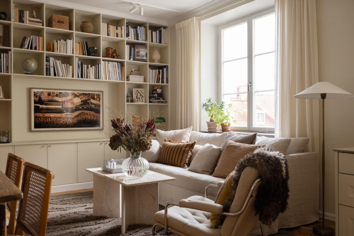 A Beige Color Palette and Built-in Bookshelves in a 1920s Apartment 4 serene living room large window built-in bookshelves