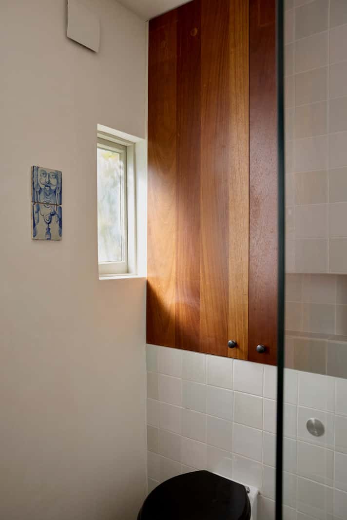 small bathroom wooden built-in storage cabinet above toilet
