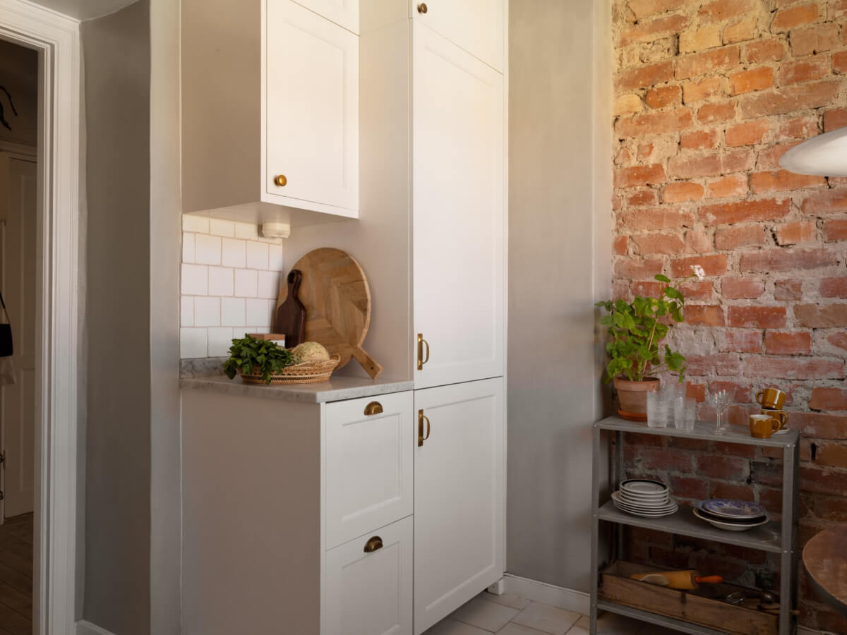 A Small Light-Filled Corner Apartment with Original Details 16 classic white kitchen cabinets brass handles