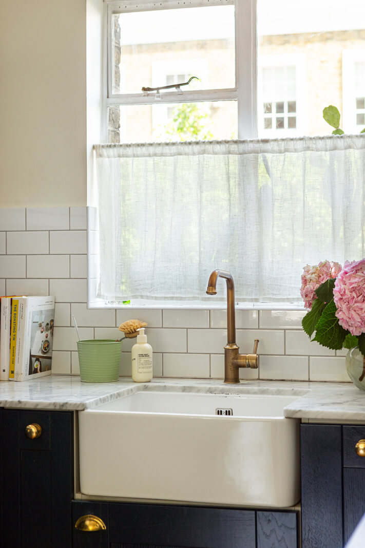 An Open-Plan Living Space and Colorful Bedrooms in a London Duplex 9 dark blue kitchen cabinets butler sink brass fittings marble countertop