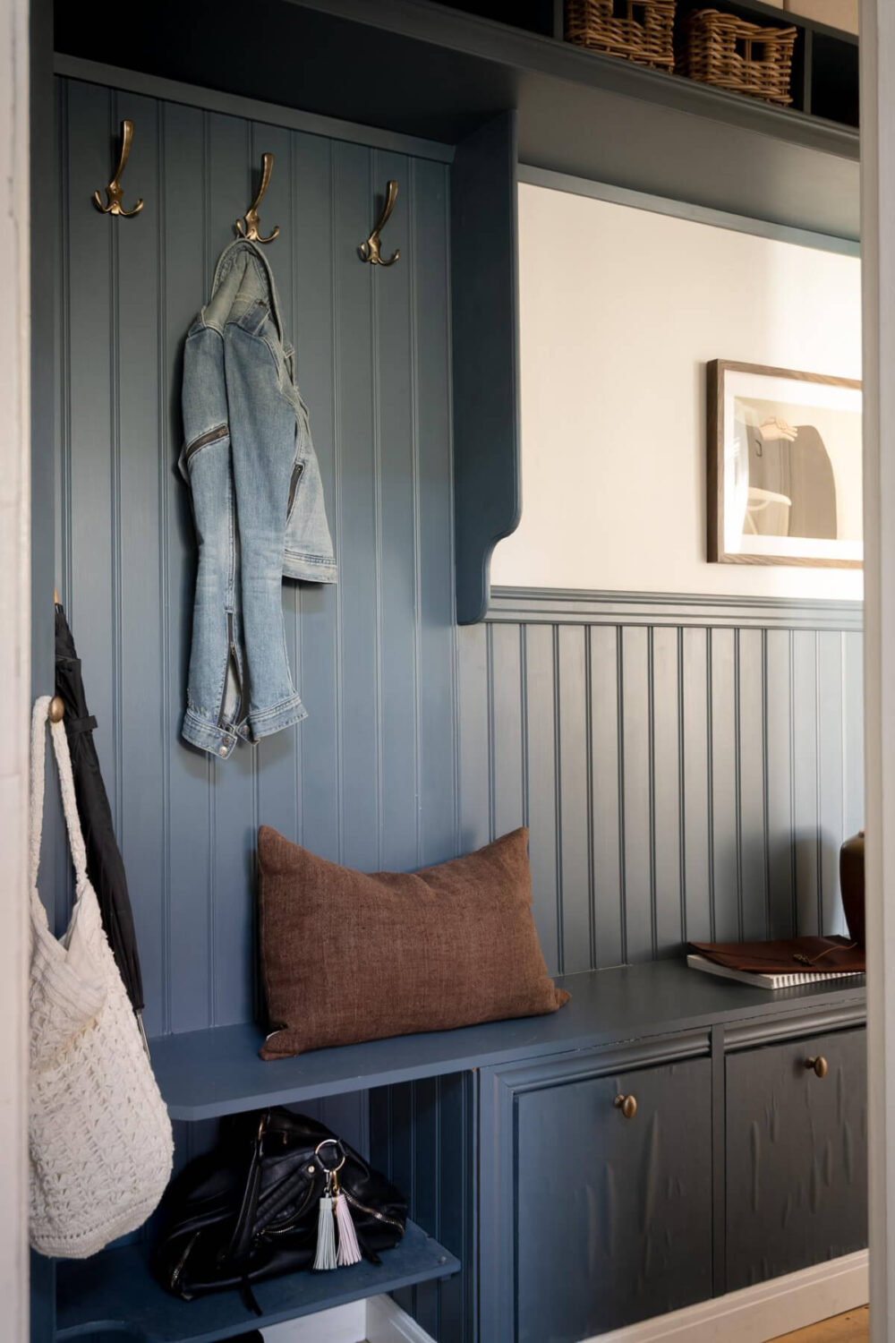 A Cozy Swedish Apartment with a Walk-In Pantry in the Sage Green Kitchen 32 dark blue paneled hall bench and storage