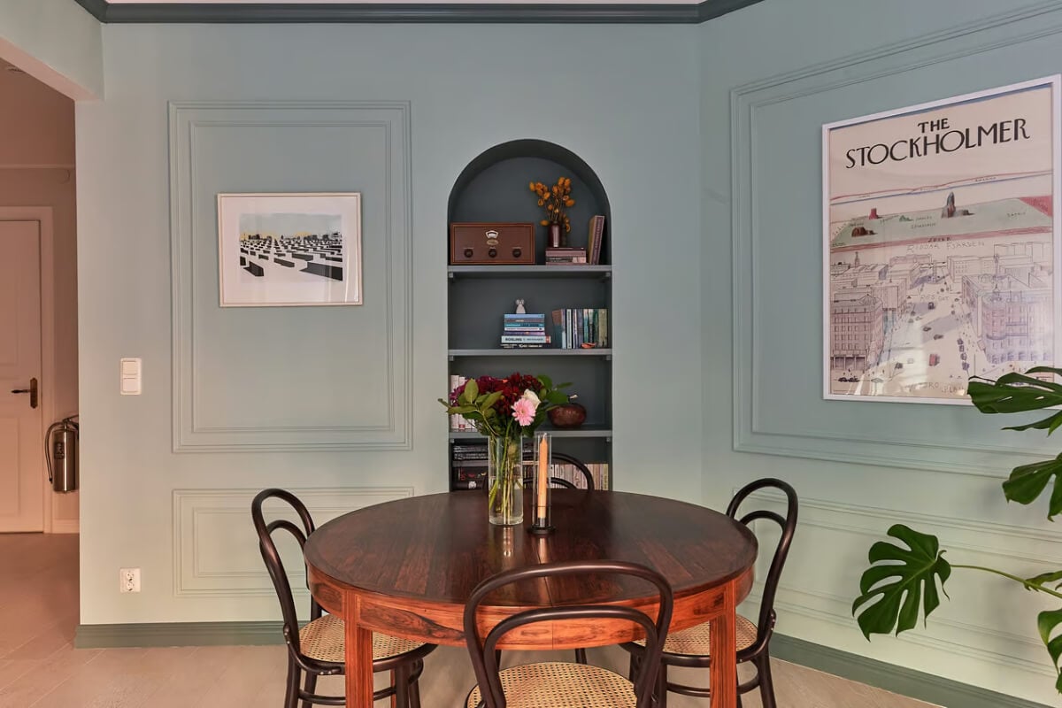 A Green Swedish Corner Apartment with an Open Floor Plan 7 dining area arched built-in bookshelves