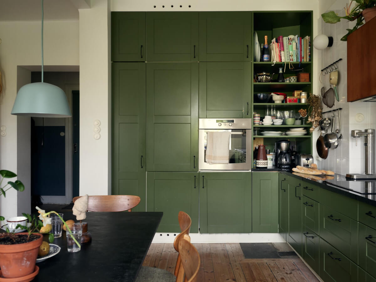 An Art Nouveau Apartment with a Deep Green Kitchen 3 floor to ceiling cabinets green doors