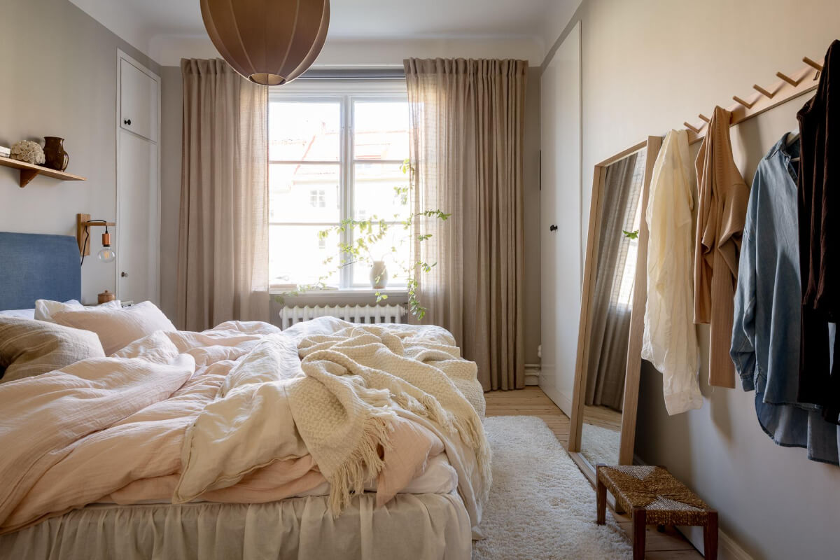 A Cozy Swedish Apartment with a Walk-In Pantry in the Sage Green Kitchen 20 gray bedroom blue headboard large window