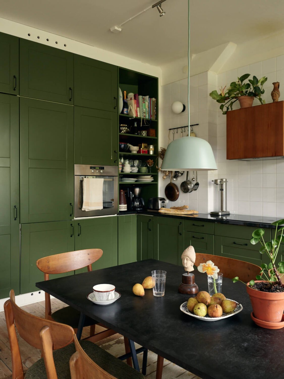 An Art Nouveau Apartment with a Deep Green Kitchen 4 green kitchen large dining table