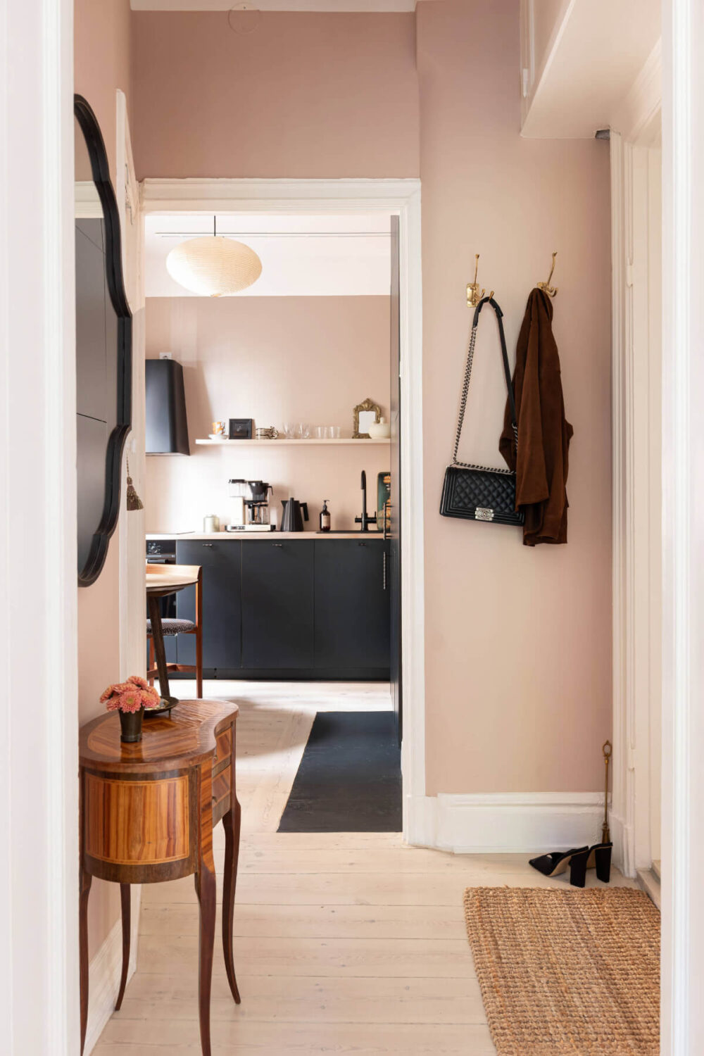 A Pink Studio Apartment with a Modern Black Kitchen 9 hall view into kitchen
