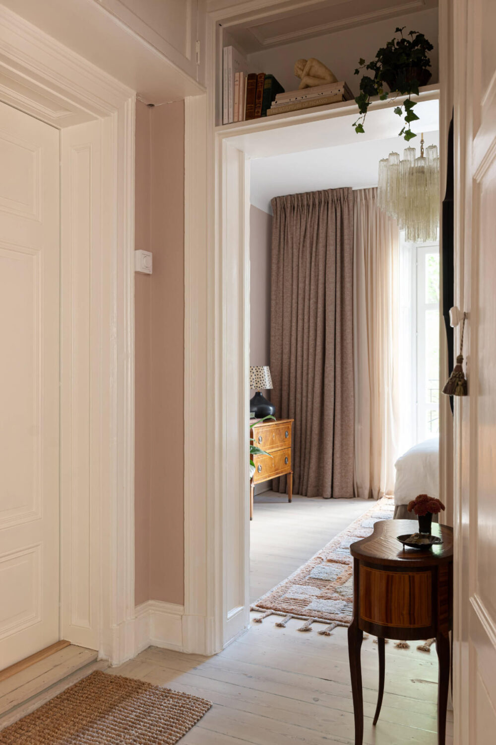 A Pink Studio Apartment with a Modern Black Kitchen 7 hall view into studio shelf above door