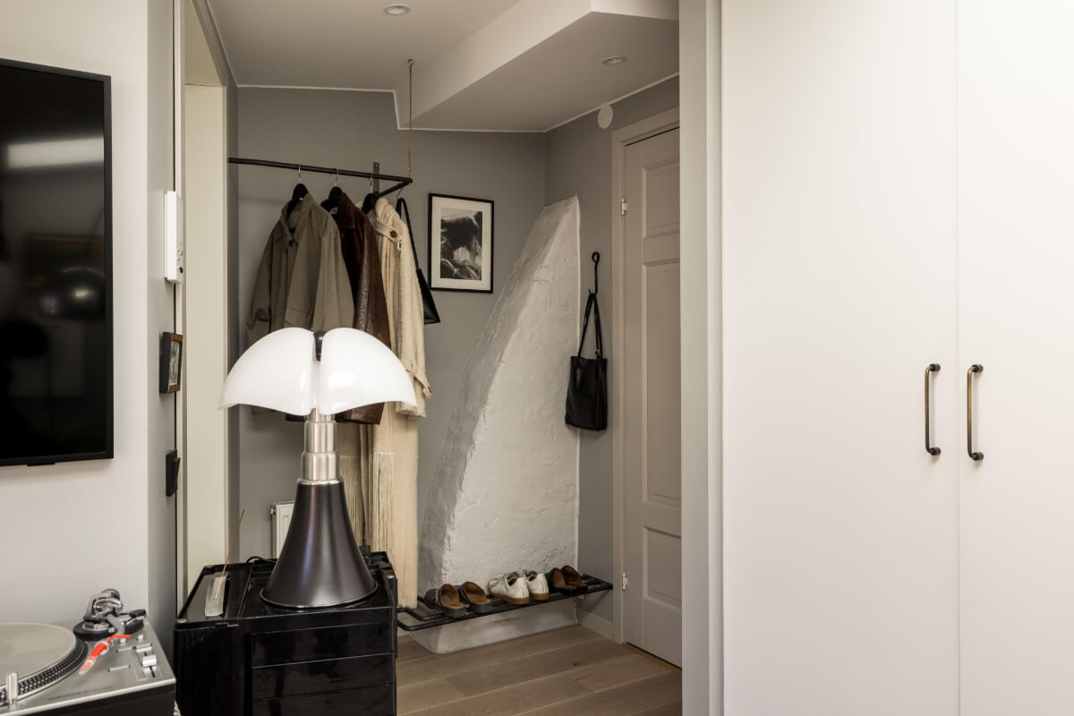 hall with coat rack and stone wall A Small, Cozy Attic Apartment with a Large Terrace
