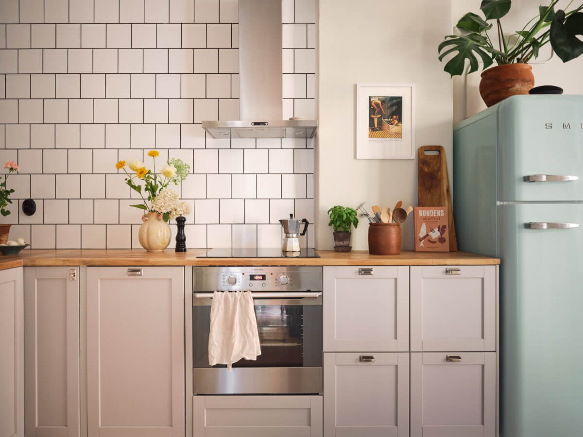 kitchen light gray cabinets wooden countertop white backsplash tiles