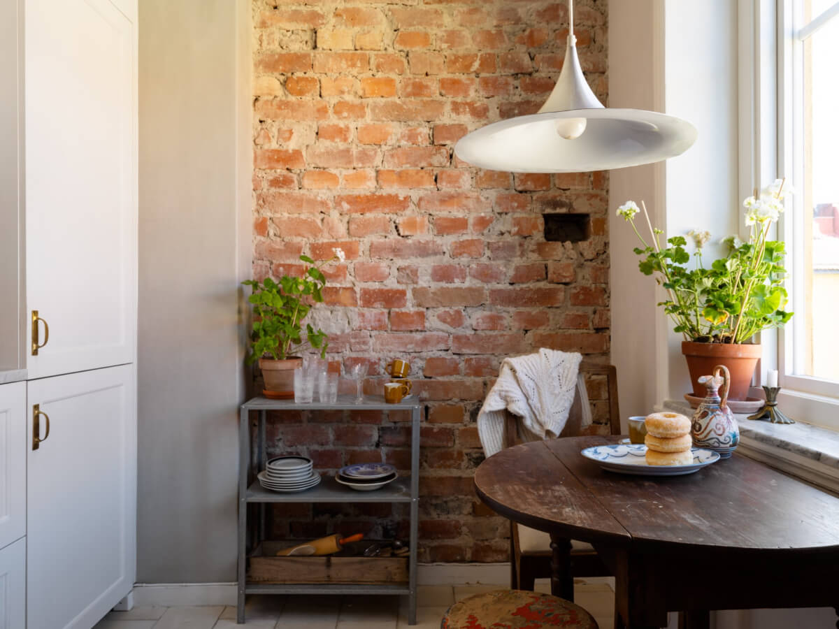 A Small Light-Filled Corner Apartment with Original Details 13 kitchen vintage wooden table exposed brick wall A Small Light-Filled Corner Apartment with Original Details