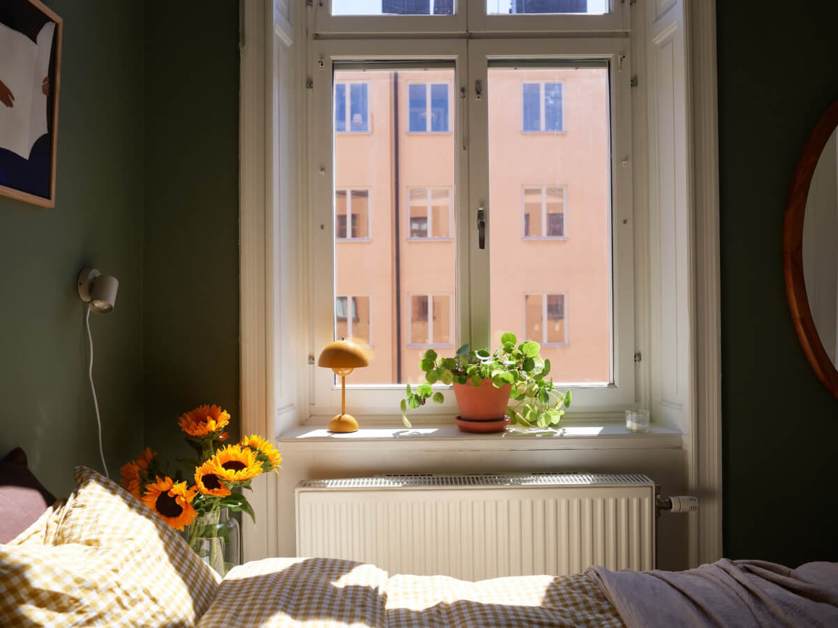 A Light-Filled Stockholm Apartment with Bright Color Pops 13 large window green bedroom