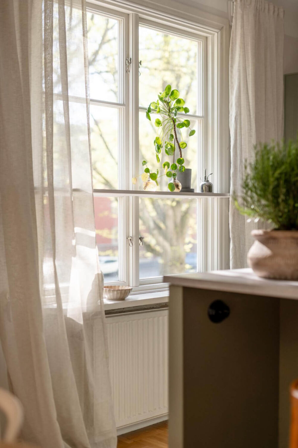 A Cozy Swedish Apartment with a Walk-In Pantry in the Sage Green Kitchen 15 large window with shelf