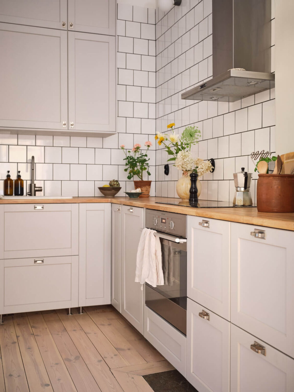 light gray kitchen cabinets white backsplash tiles wooden floro