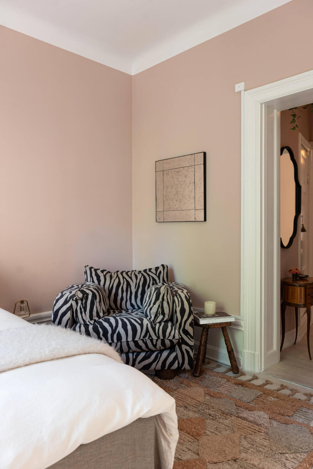 A Pink Studio Apartment with a Modern Black Kitchen 6 pink studio zebra patterned chair