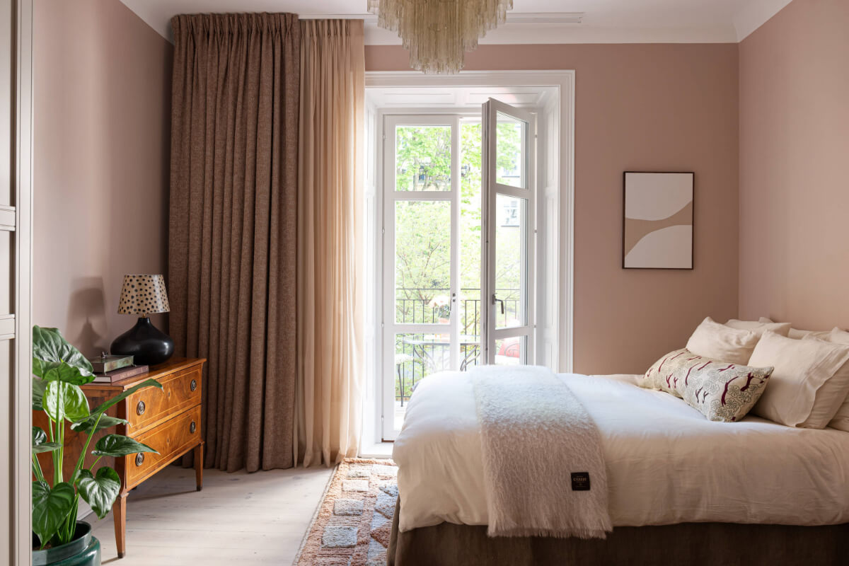 A Pink Studio Apartment with a Modern Black Kitchen 1 pink walls studio apartment antique dresser