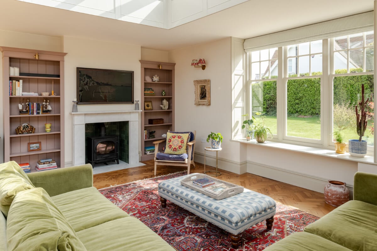 A Grand Edwardian Villa with a Yellow Kitchen and Coastal Views 3 sitting room fireplace lavender bookshelves