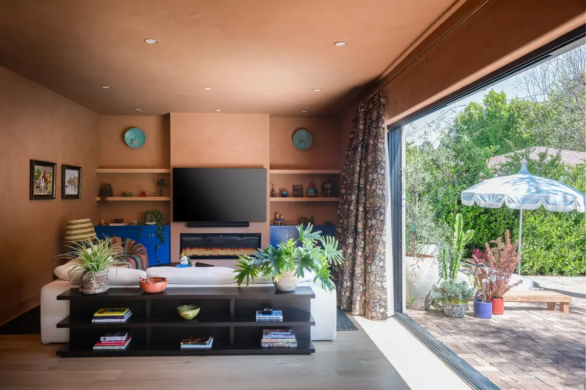 A Creative Sanctuary in Sherman Oaks Designed by Mendy Cheng 6 terracotta colored walls ceiling living room open connection to garden