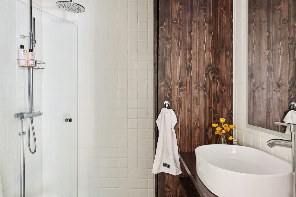 A Green Swedish Corner Apartment with an Open Floor Plan 19 white bathroom with dark wooden cabinets