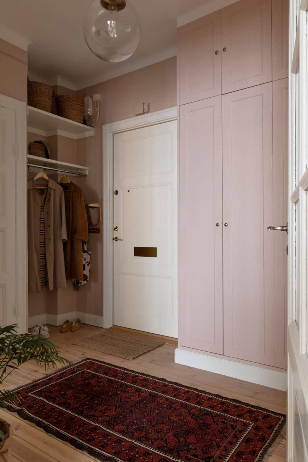 hall with pink walls and built-in wardrobes