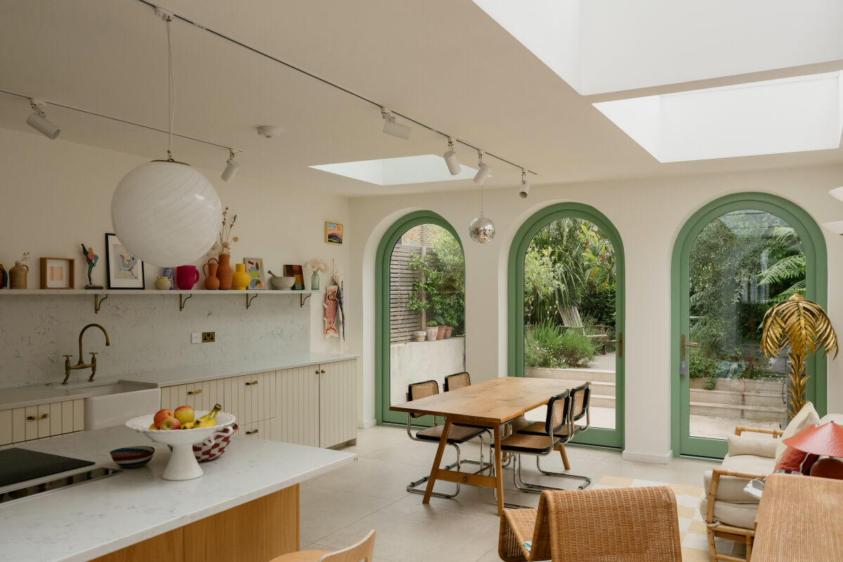 kitchen extension green arched windows wooden dining table