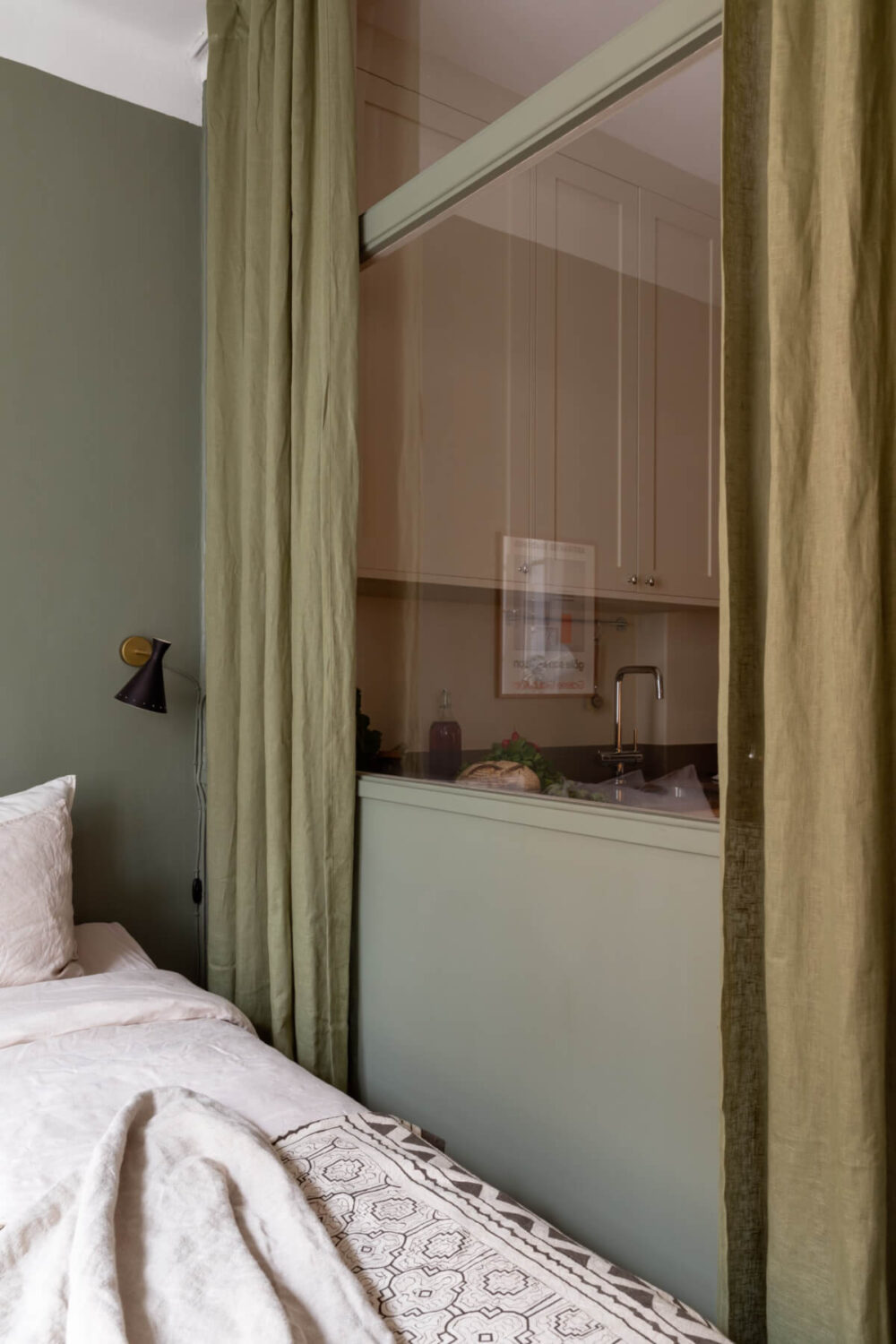 parition wall with glass toward kitchen green curtains