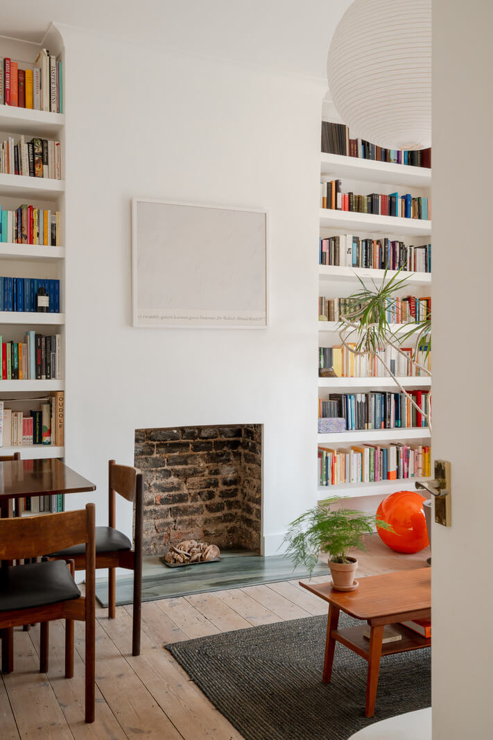 white living room wooden floor bookshelves fireplace