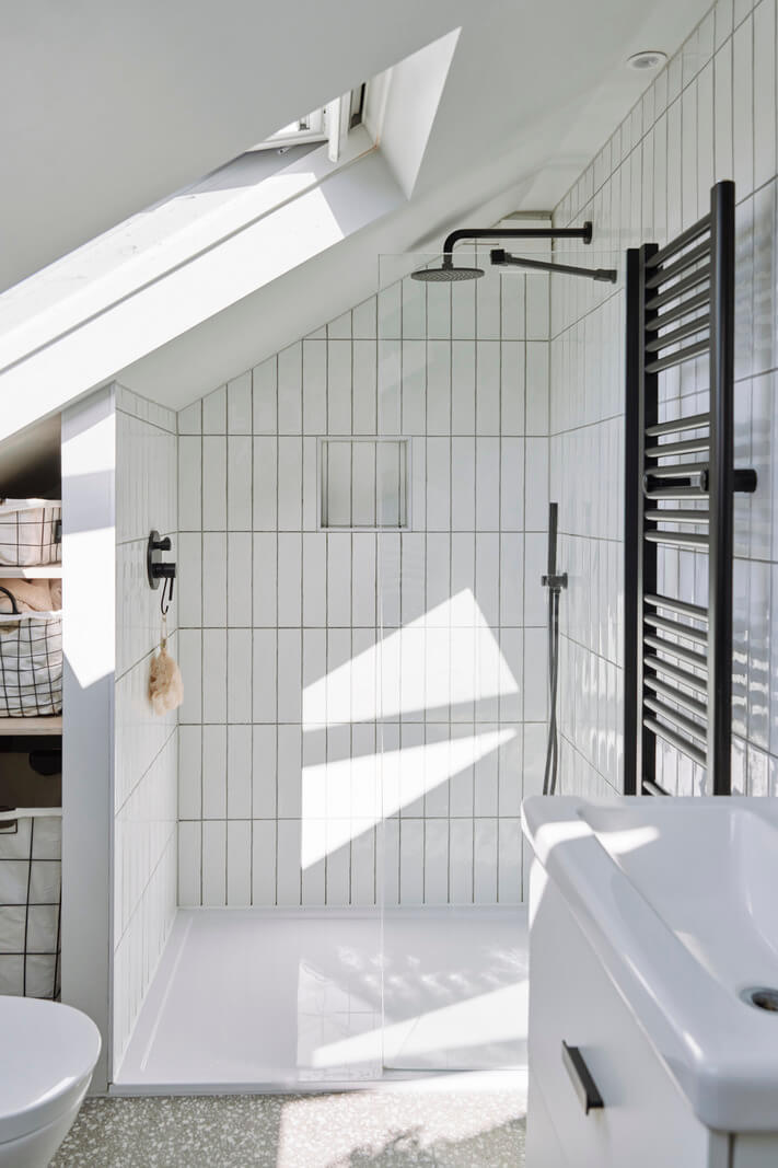 Colorful Rooms and a Modern Kitchen in a Spacious Family Home 21 bathroom slanted ceiling white tiles skylight