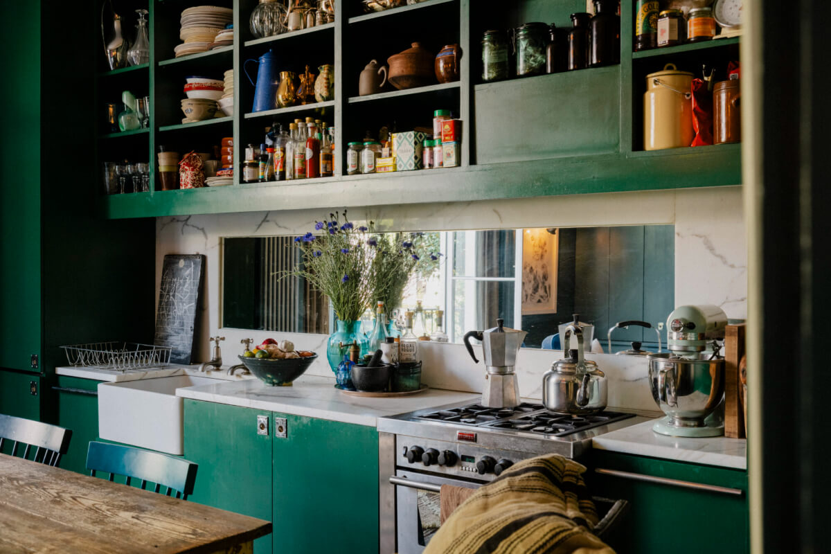green kitchen with marble and mirror backsplash