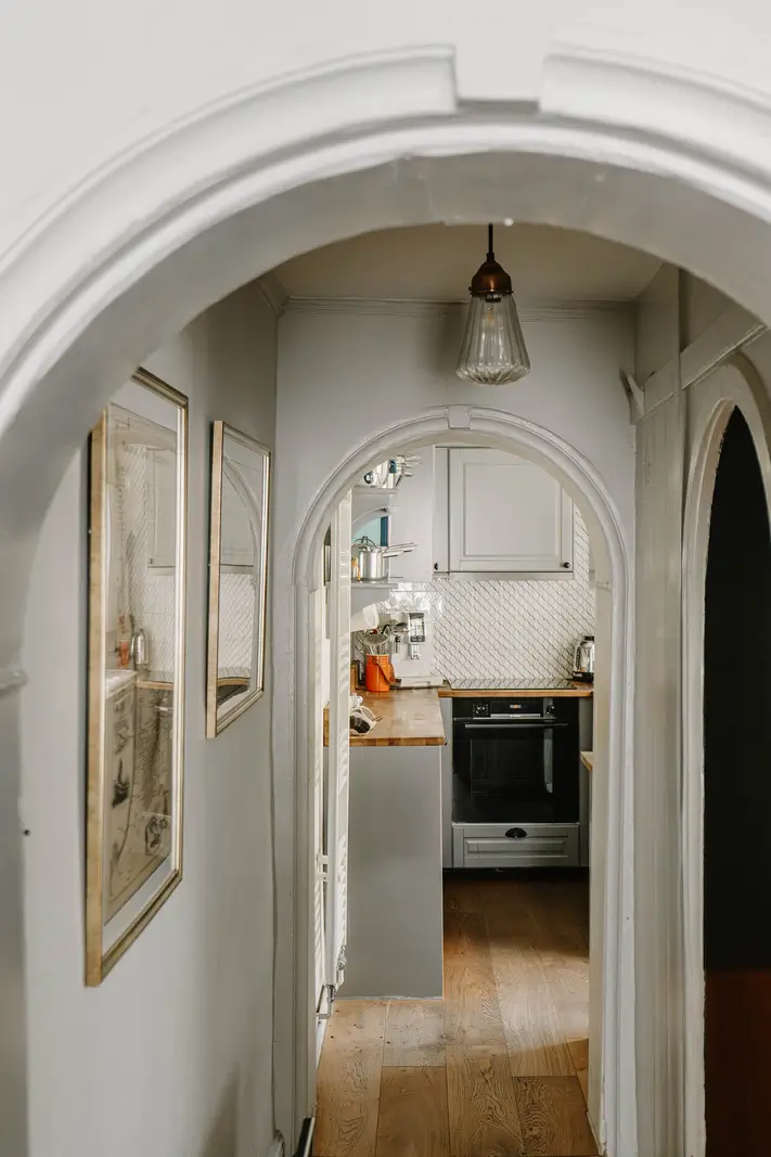 arched doorway into small gray kitchen