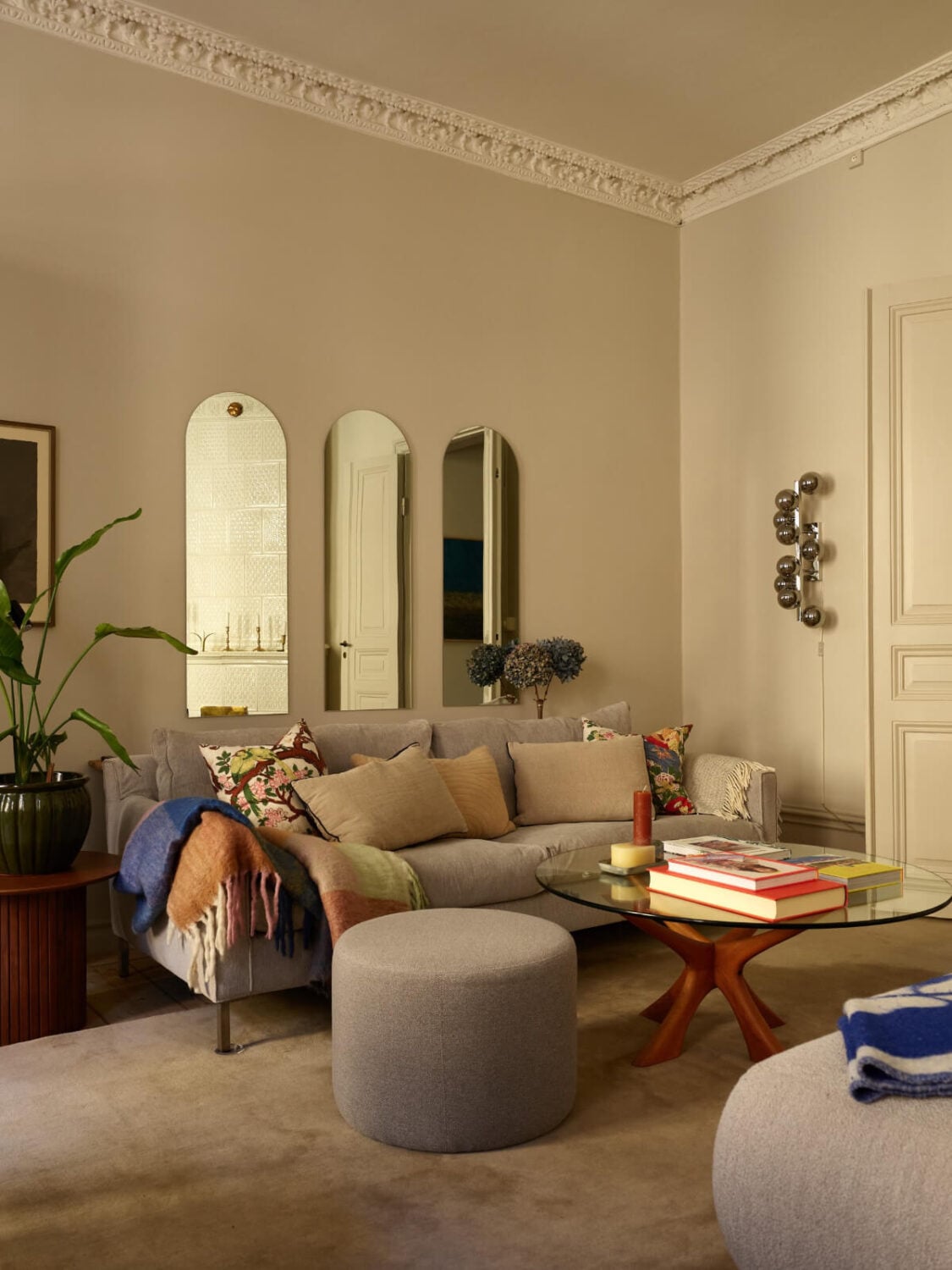 Blue and Red Color Accents in a Stylish Scandinavian Apartment 2 arched mirrors above gray sofa