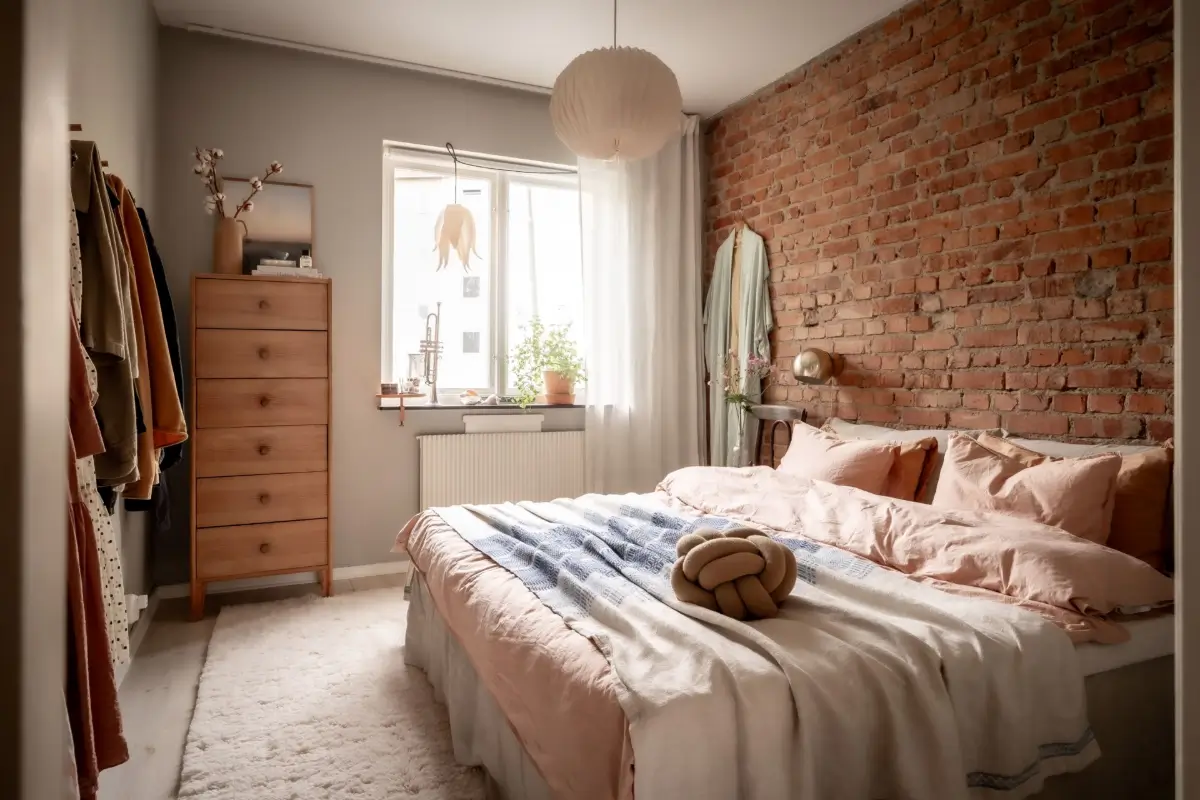 An Earthy Color Palette and Exposed Brick in a 1940s Apartment 17 bedroom exposed brick wall blush bedding