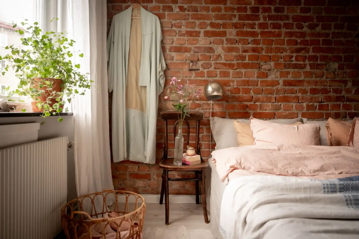 An Earthy Color Palette and Exposed Brick in a 1940s Apartment 19 bedroom exposed brick wall chair bedside table nordroom