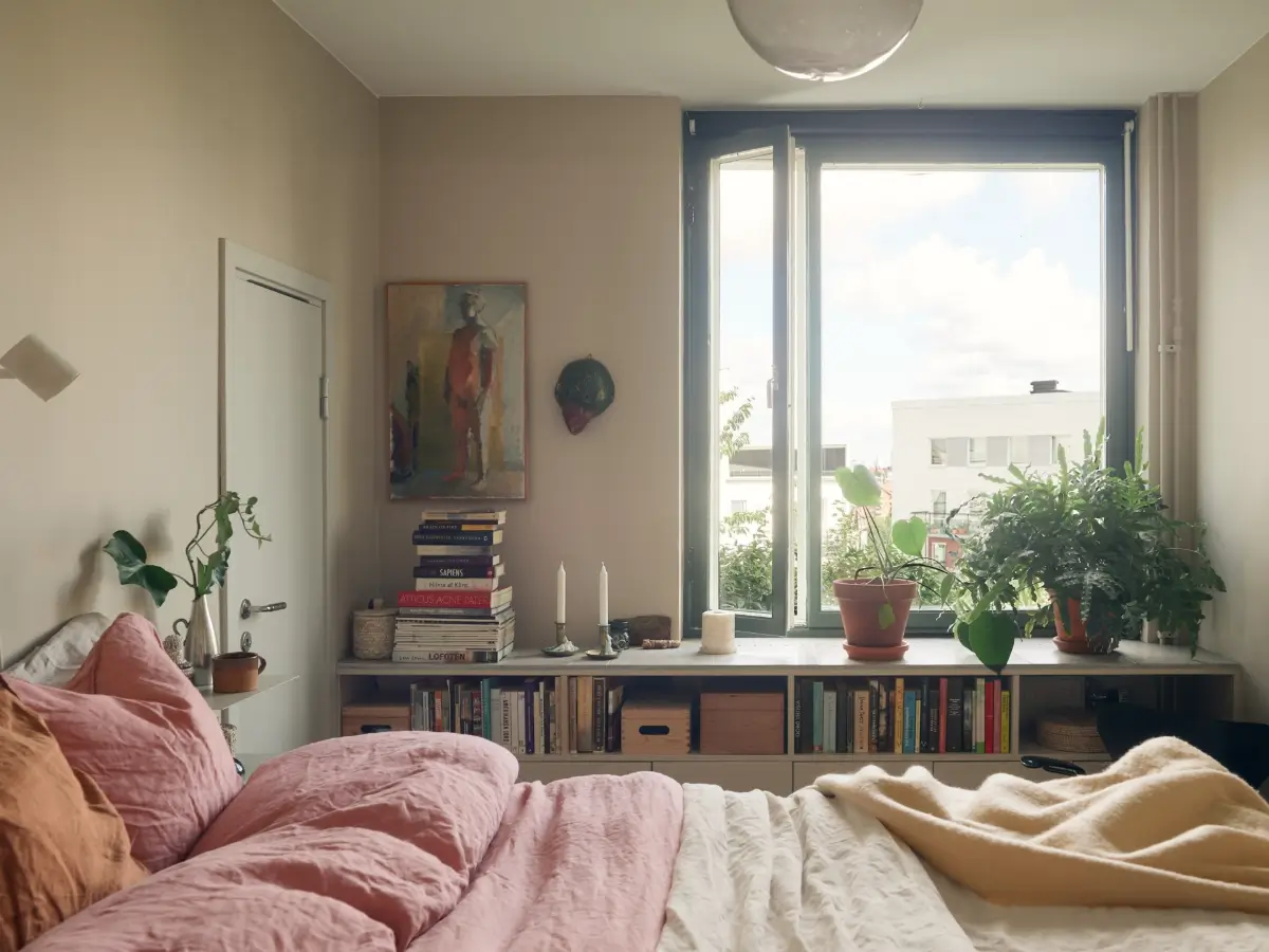 Industrial Elements in a 1960s Duplex Apartment in Stockholm 37 beige bedroom open cabinets under window pink bedding nordroom